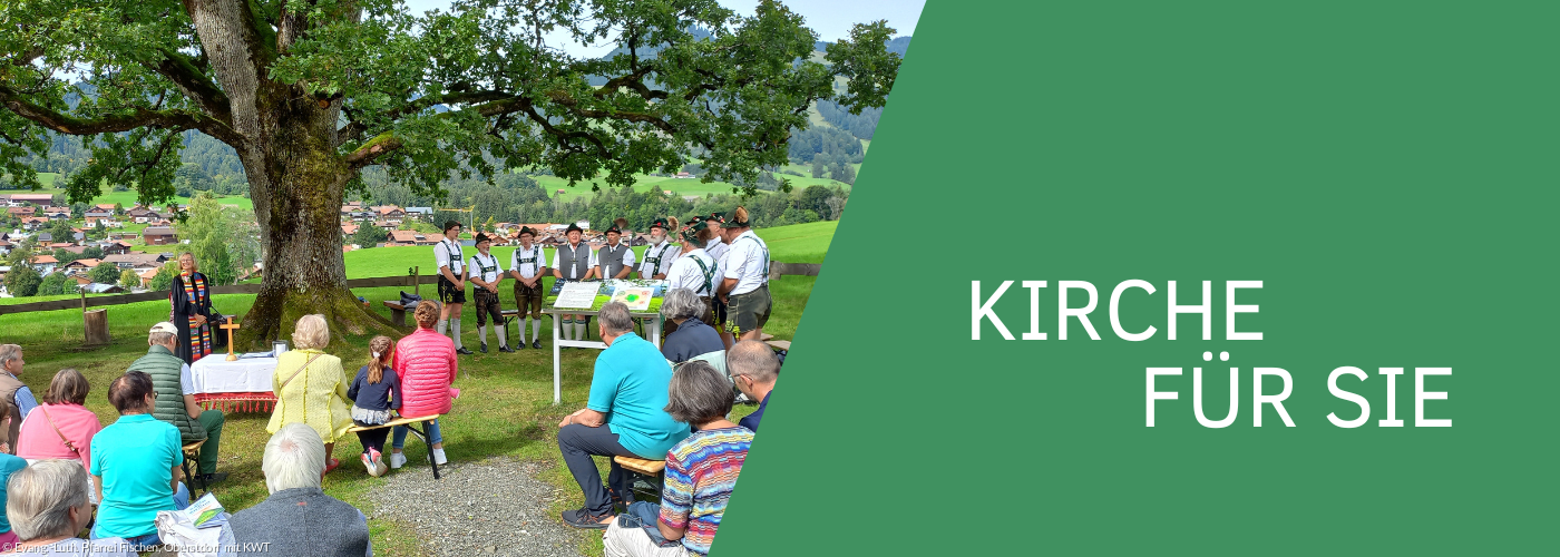 Gottesdienst im Grünen unter einem großen Baum auf einer Wiese
